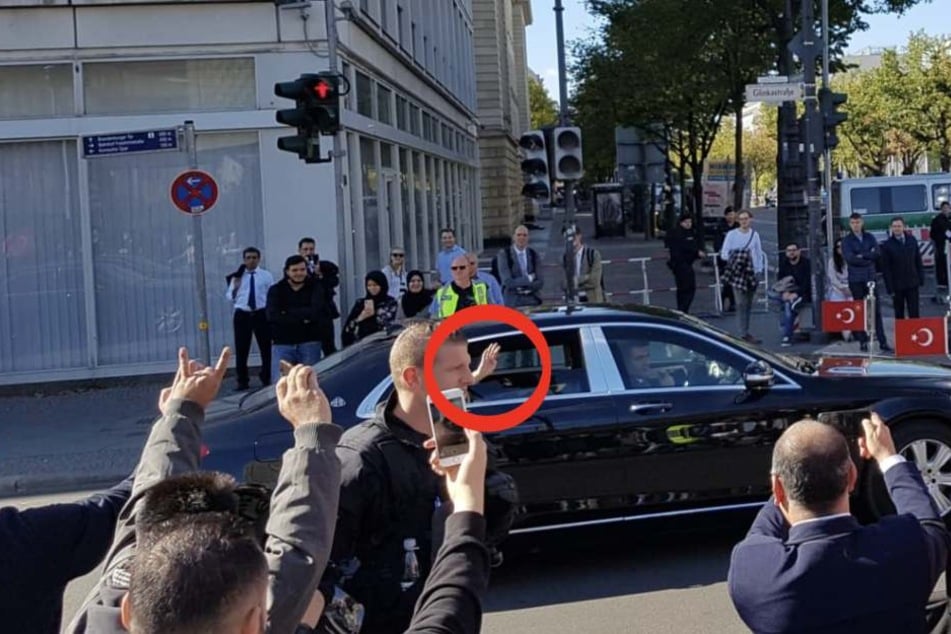 Erdogan im Mercedes-Maybach zeigt mit vier Fingern den islamistischen Gruß (Kreis). Seine Anhänger grüßen mit der "Wolfsschnauze" zurück.
