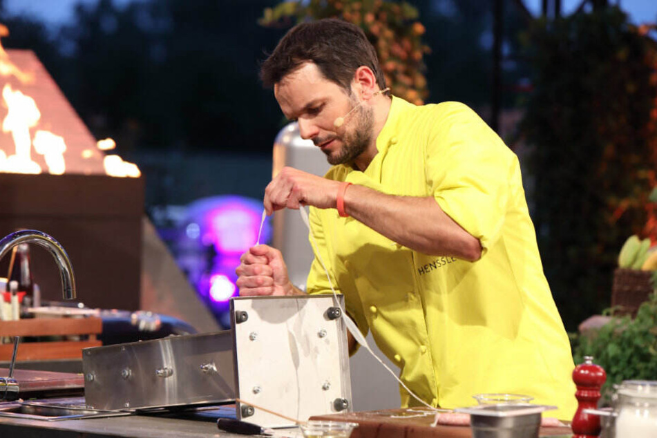 Steffen Henssler im Kampf mit einer Wurst-Maschine.