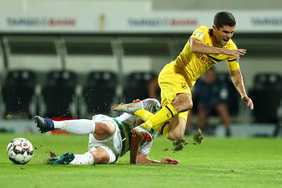 Fürths Abwehrmann Maximilian Bauer (l.) grätscht Dortmund Christian Pulisic (r.) um.