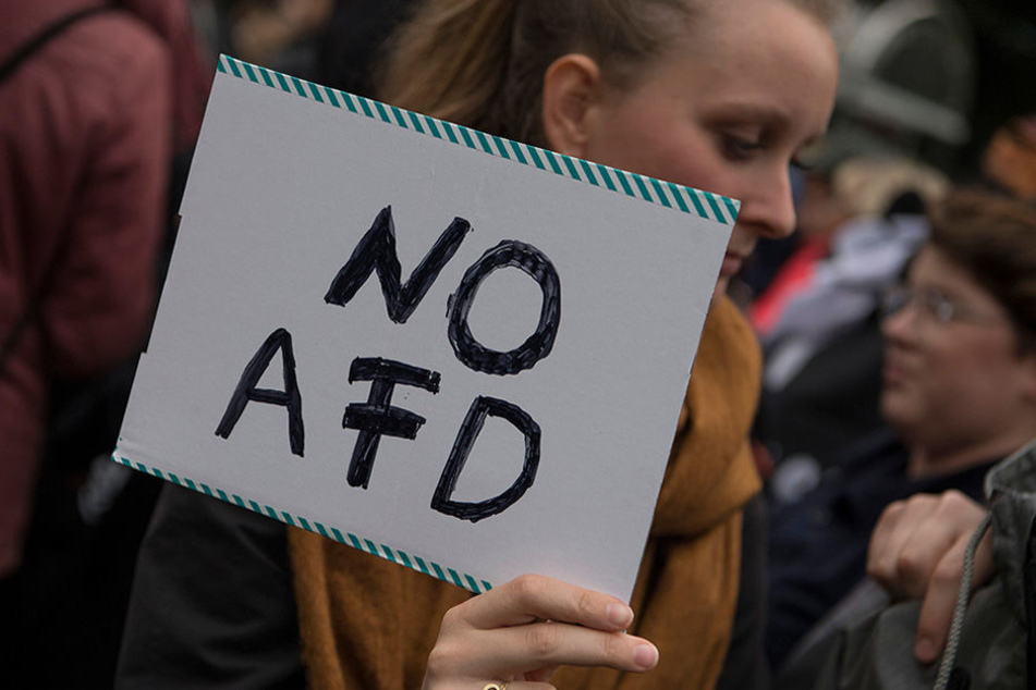 Eine Demonstrantin hält ein Schild mit der Aufschrift "No AFD" hoch.