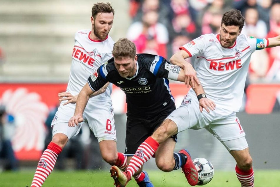 Kölns Marco Höger (l) und Kölns Jonas Hector (r) im Kampf um den Ball mit Bielefelds Fabian Klos.
