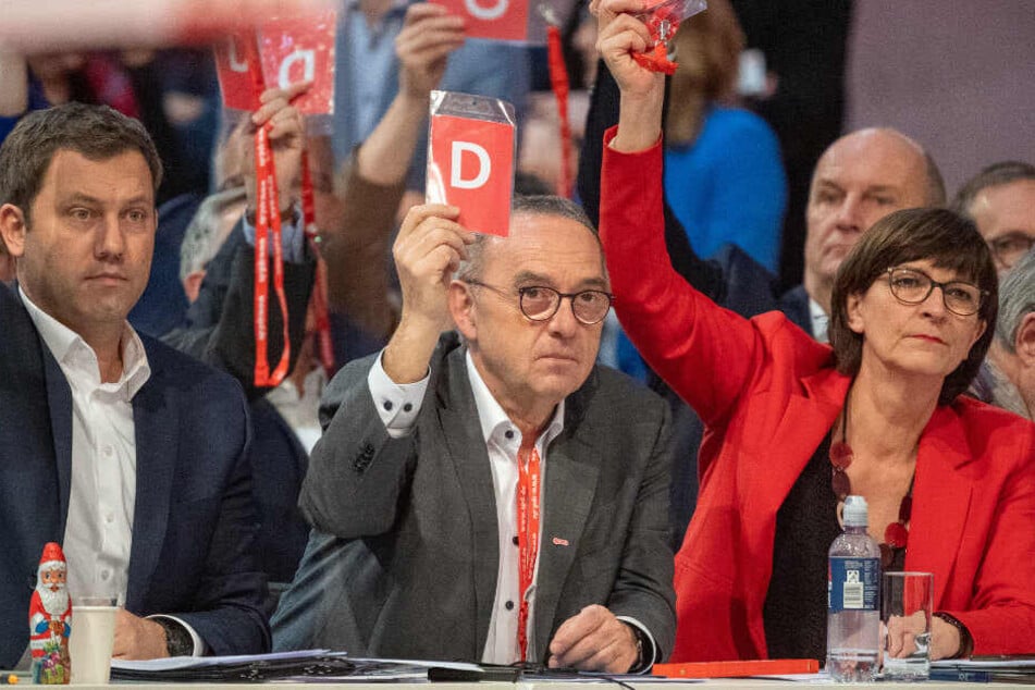 Saskia Esken (r-l) hält neben Norbert Walter-Borjans und Lars Klingbeil beim SPD-Bundesparteitag die Stimmkarte hoch.