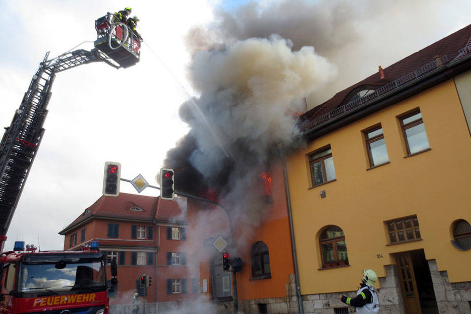 Flammen und dichte Rauchwolken schlagen aus den Fenstern des Eckhauses am Weimarer Stadtring.