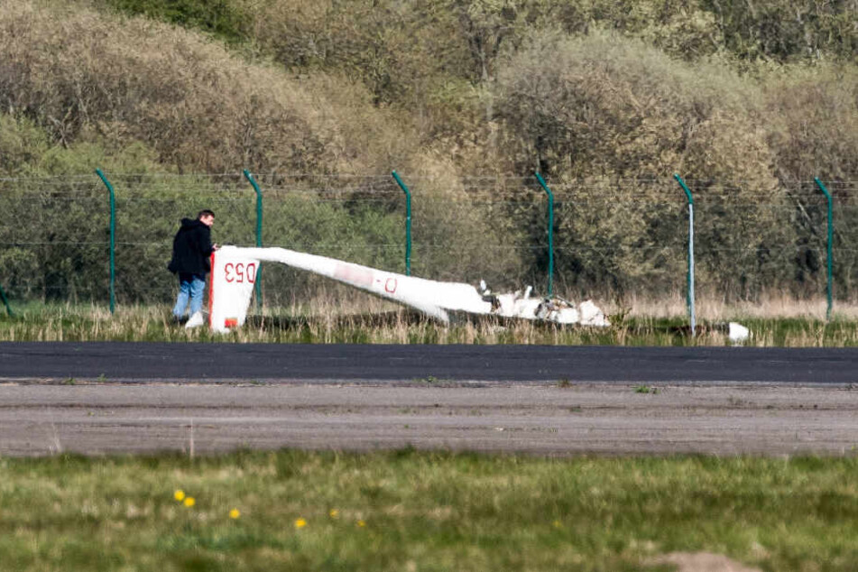 Das Flugzeugwrack liegt auf einem Feld nahe der Landebahn.