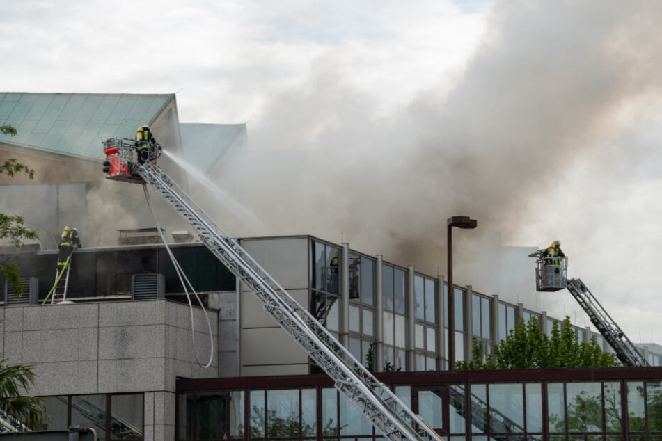 Feuerwehrleute löschen den Brandherd auf dem Dach.