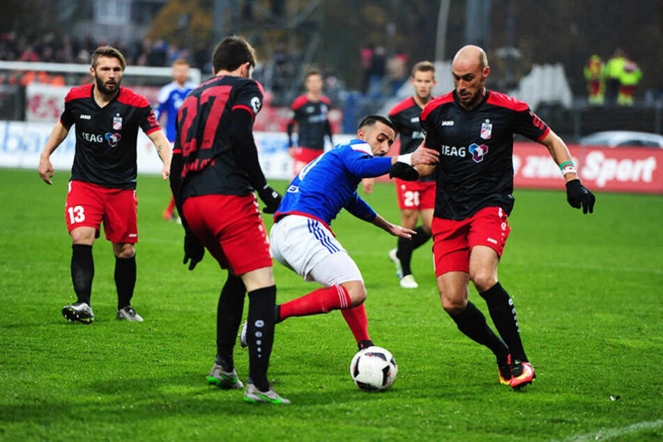 Der Kieler Milad Salem gegen die Erfurter Carsten Kammlott (l.) und Daniel Brückner im Duell.