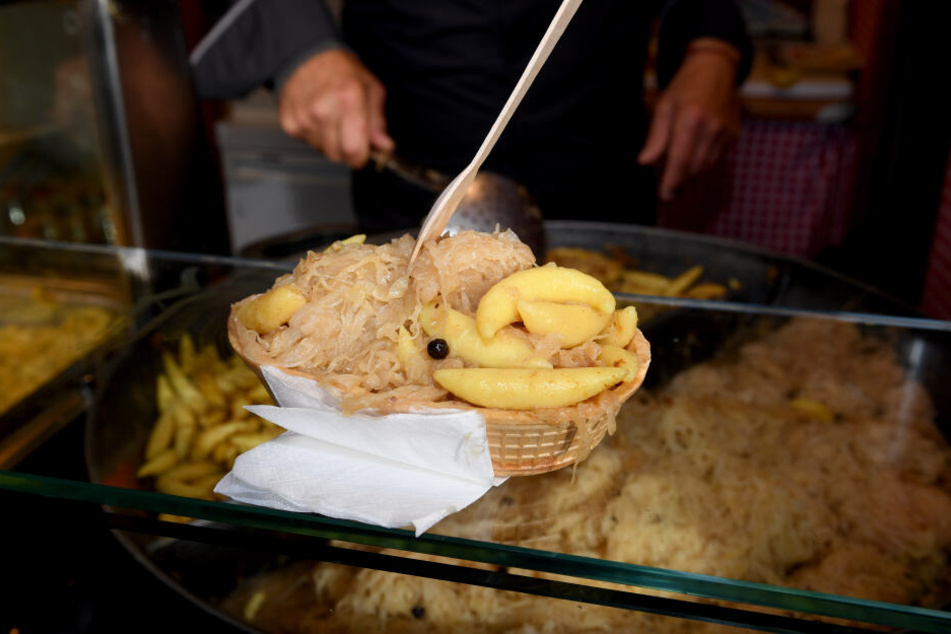 Eine Waffel als essbare Schale gefüllt mit Schupfnudeln und Sauerkraut steht im Stand "Altbayerische Spezialitäten" auf der Wiesn zum Verkauf bereit.