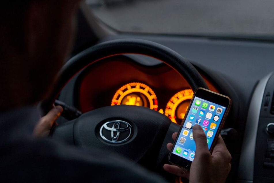 Die Frau saß am Steuer und nutzte ihr Handy. (Symbolbild)