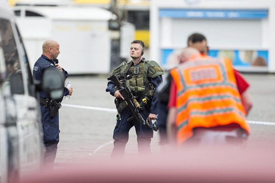 Ein schwer bewaffneter Polizist steht auf dem Marktplatz in Turku.
