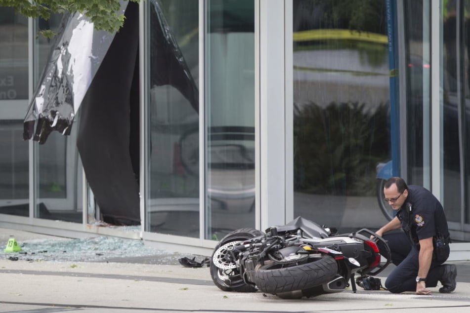 Ein Polizist untersucht das Motorrad der Stuntfrau.