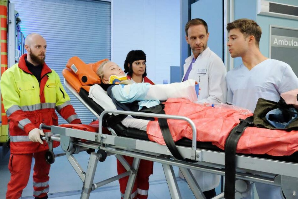 Laura Schütz wird mit einem gebrochenen Arm in die Sachsenklinik eingeliefert. Pfleger Kris Haas (r.) erkennt sofort die ehemalige Patientin von Dr. Philipp Brentano wieder.
