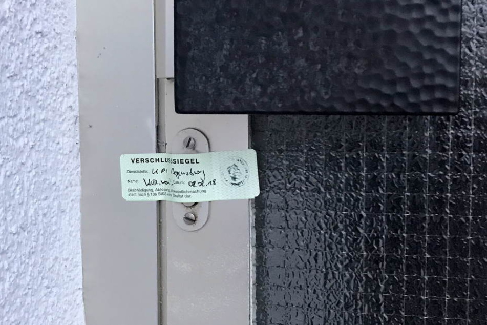 Ein Siegel der Polizei klebt an der Eingangstüre zu einem Wohnhaus. Die Polizei hat dort in der Nacht eine tote Frau und einen schwer verletzten Mann gefunden.