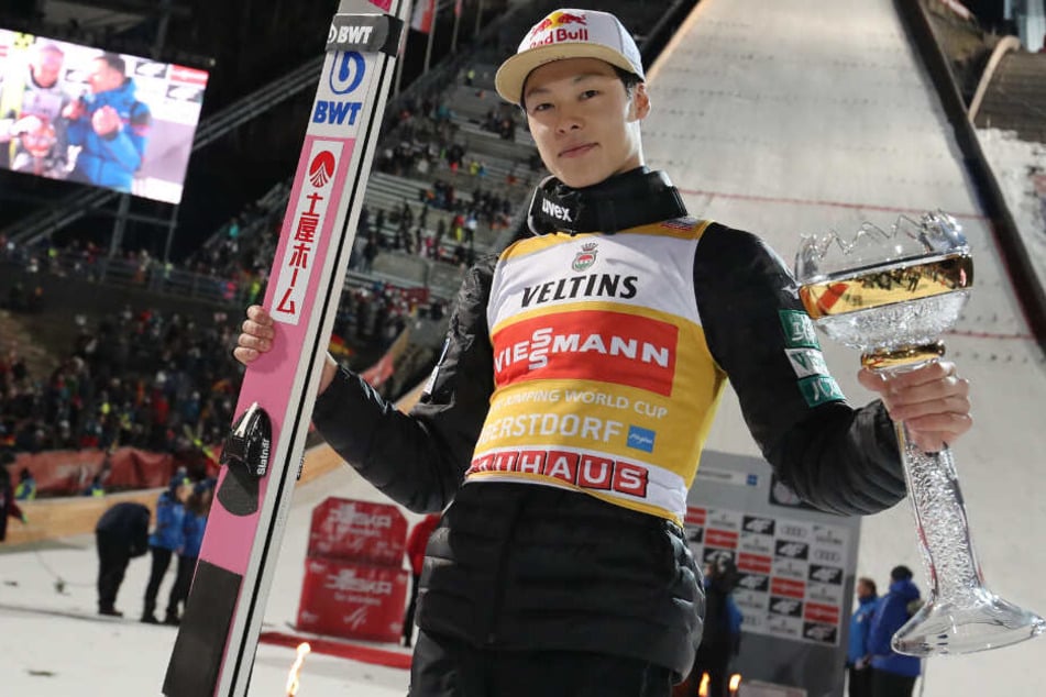Ryoyu Kobayashi aus Japan feiert seinen Sieg mit dem Pokal.