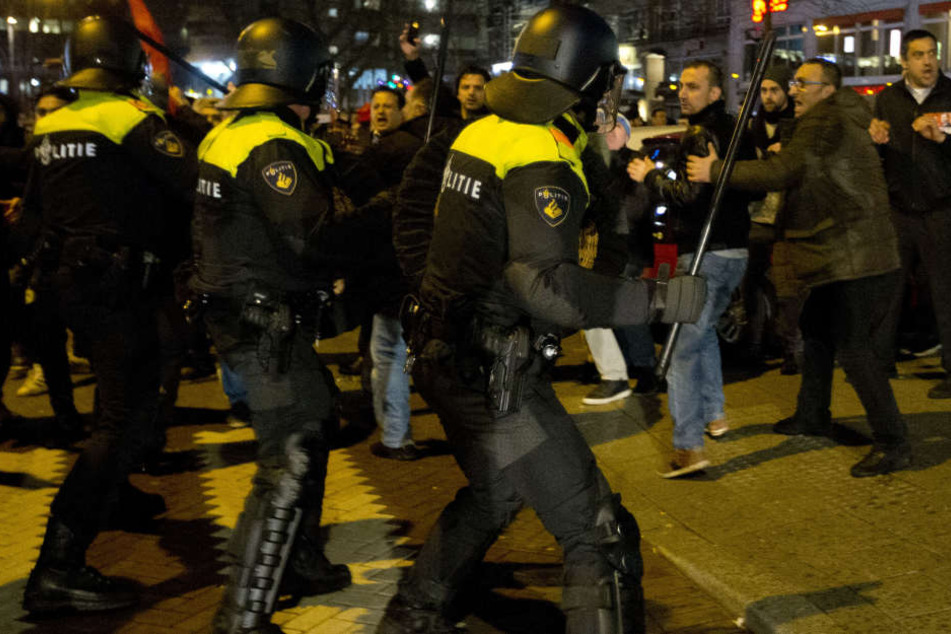 Polizeieinheiten stehen am türkischen Konsulat in Rotterdam Demonstranten gegenüber.
