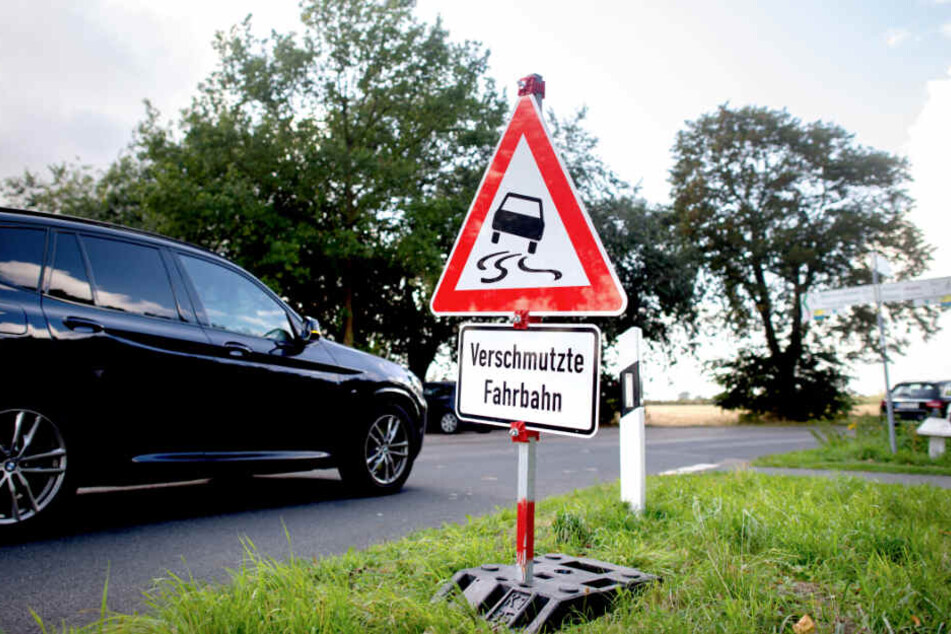 Schilder weisen Autofahrer auf eine wegen der Wollhandkrabben verschmutzten Fahrbahn hin.