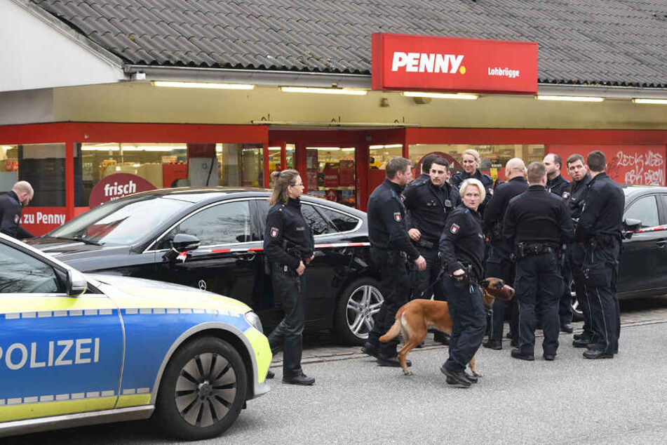 Polizeibeamte stehen vor dem Supermarkt in Lohbrügge.