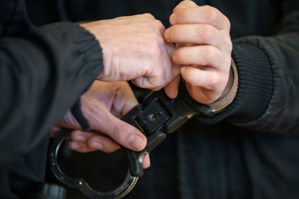 Dem Angeklagten werden beim Betreten des Gerichtssaales die Handschellen abgenommen.
