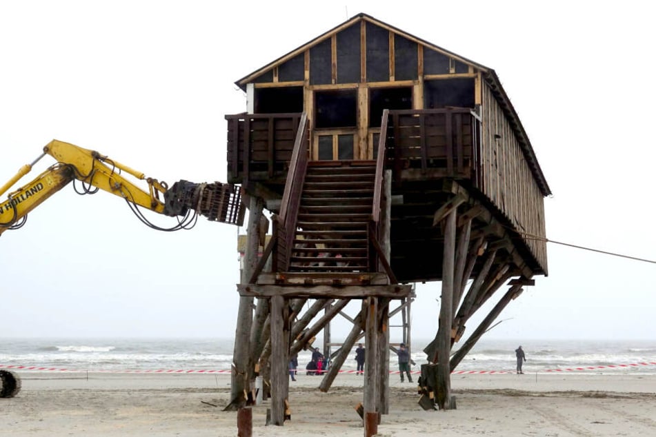 Ein Pfahlbau wird am Strand von St.Peter-Ording abgerissen. Der Bau mit Toiletten und Umkleideräumen wird durch einen Neubau ersetzt, der 100 Meter weiter ins Landesinnere gebaut wird.