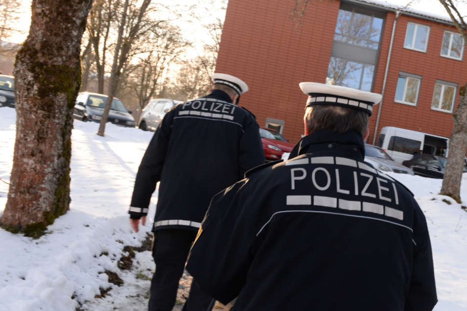 Zwei Polizisten gehen in der ehemaligen Kaserne zu einer Unterkunft, in der neue Asylbewerber untergebracht sind. (Archivbild)