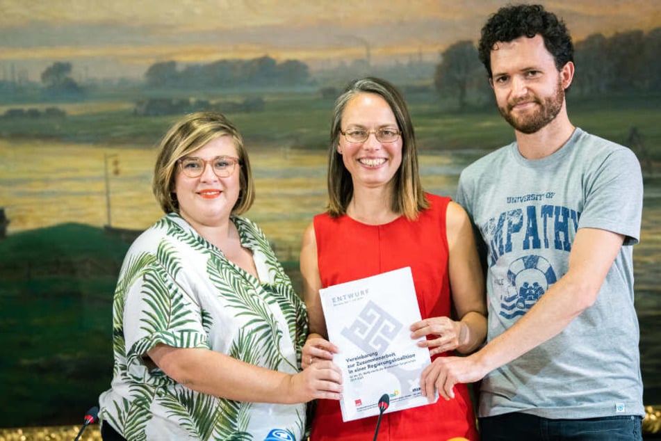 Alexandra Werwath (Grüne), Sascha Karolin Aulepp (SPD) und Felix Pithan (Linke) halten den Entwurf des Koalitionsvertrages in ihren Händen.