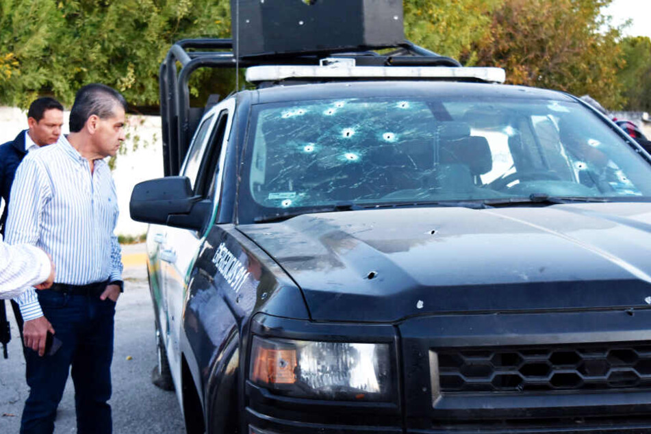 Miguel Riquelme Solis, Gouverneur von Coahuila, betrachtet ein Polizeifahrzeug mit Einschusslöchern.