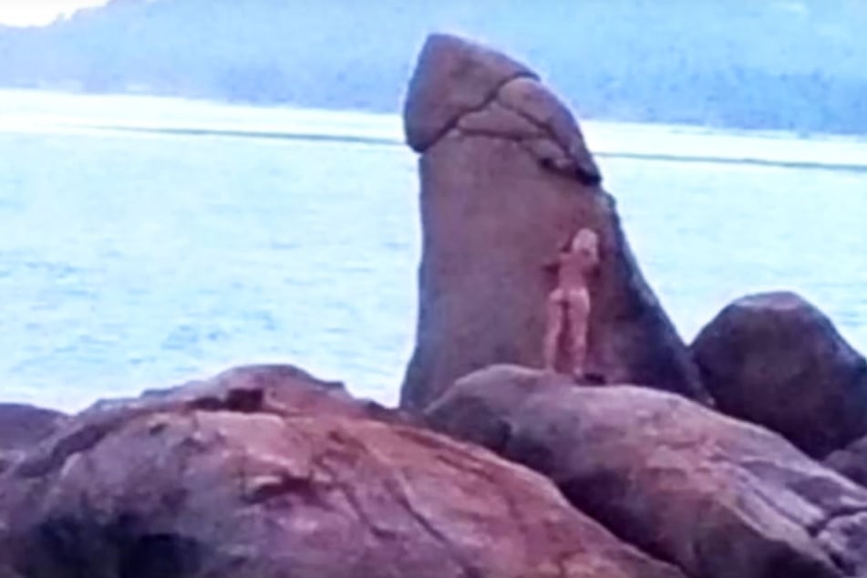 Die nackte Frau hat sichtlich Spaß mit dem Felsen-Penis.