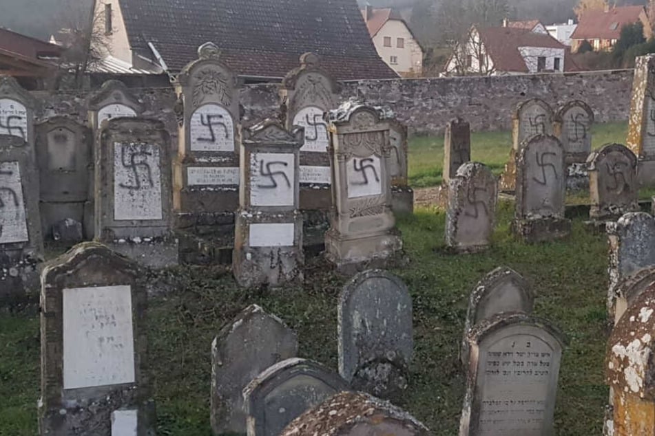 Grabsteine auf einem jüdischen Friedhof wurden mit schwarzen Hakenkreuzen beschmiert.