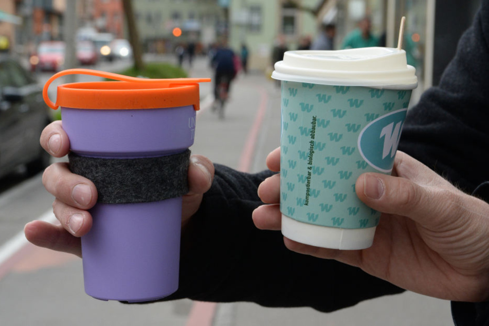 Ein Mehrweg-Kaffeebecher (l.) und ein Einweg-Kaffeebecher werden gehalten. Das Aktionsbündnis "Müllarmes Tübingen" stellte im Rahmen einer Pressekonferenz den Mehrwegbecher "treecup".