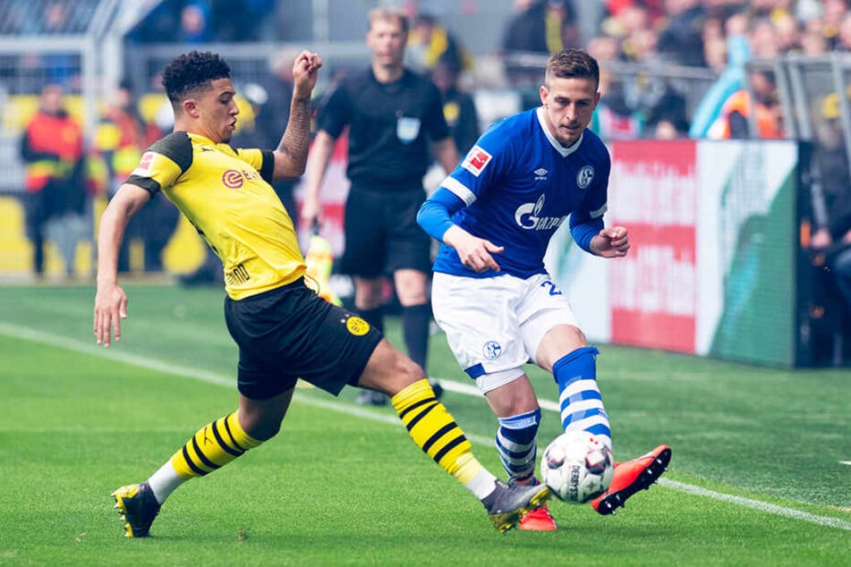 Dortmunds Jadon Sancho (l.) versucht, den Pass von Schalkes Bastian Oczipka zu verhindern.