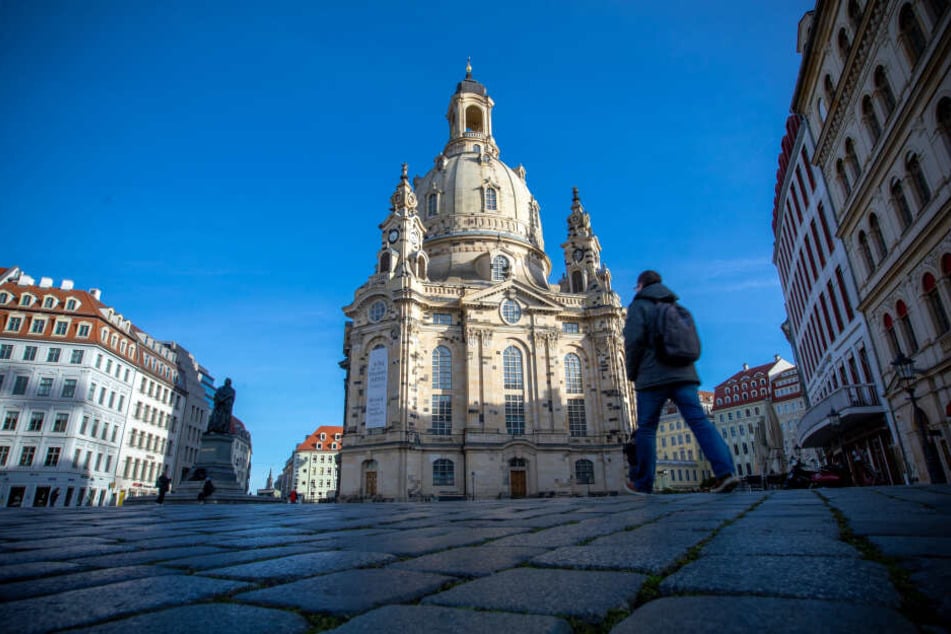 Passanten gehen am Morgen an der Frauenkirche vorbei.