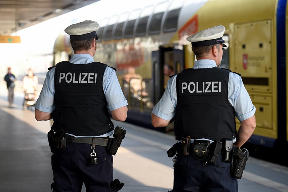 Zwei Polizisten vor einer Regionalbahn. (Symbolbild)
