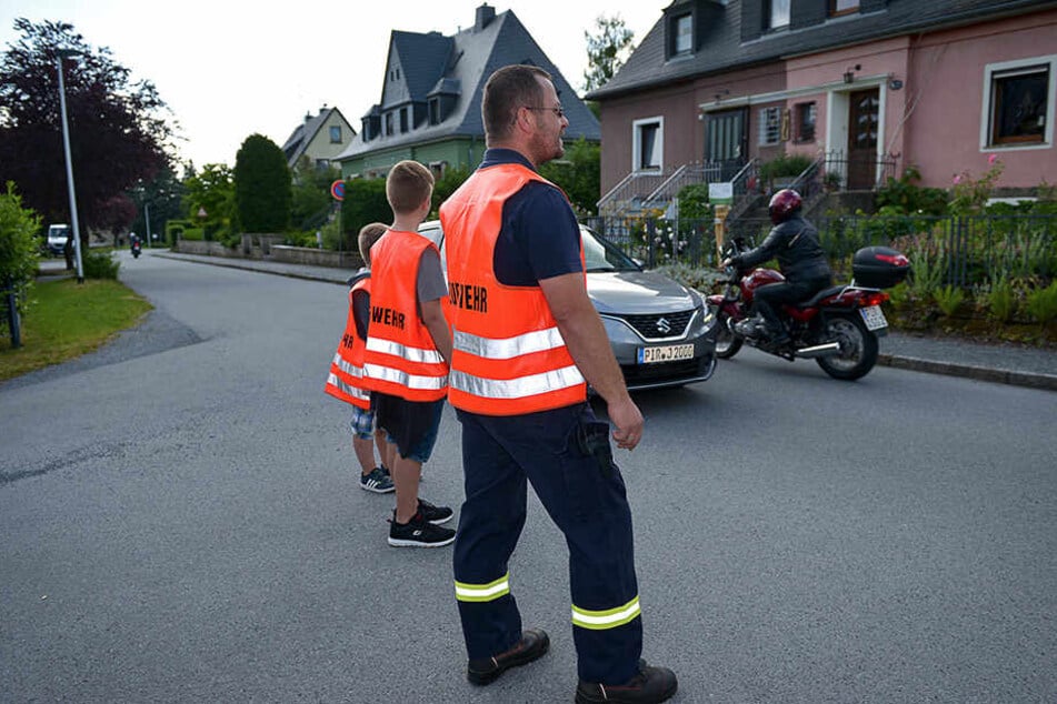 Freiwillige Feuerwehr Berggießhübel im Einsatz: Robert Smyrtek (37, v.r.), Jason (13) und Lenny (9) sperren die Ortsdurchfahrt ab.