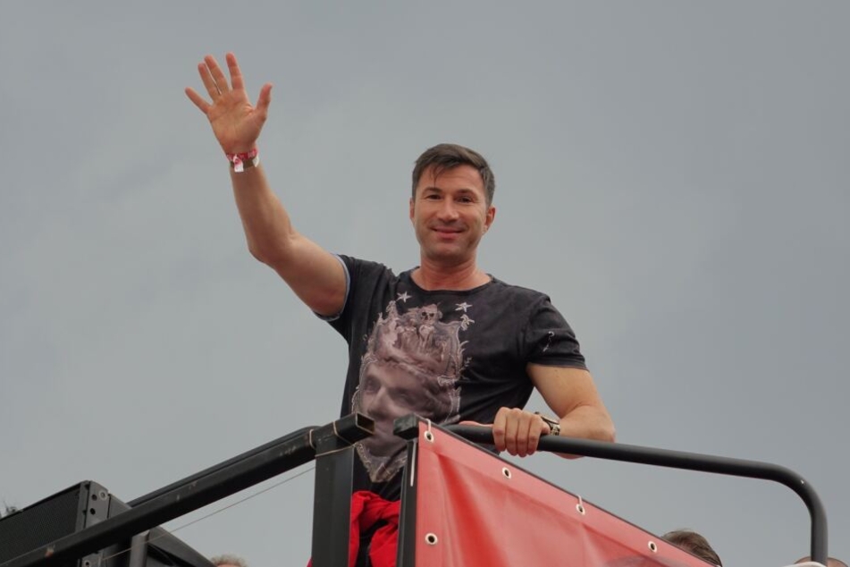 Lucas Cordalis winkt den Feiernden von einem Truck aus zu.