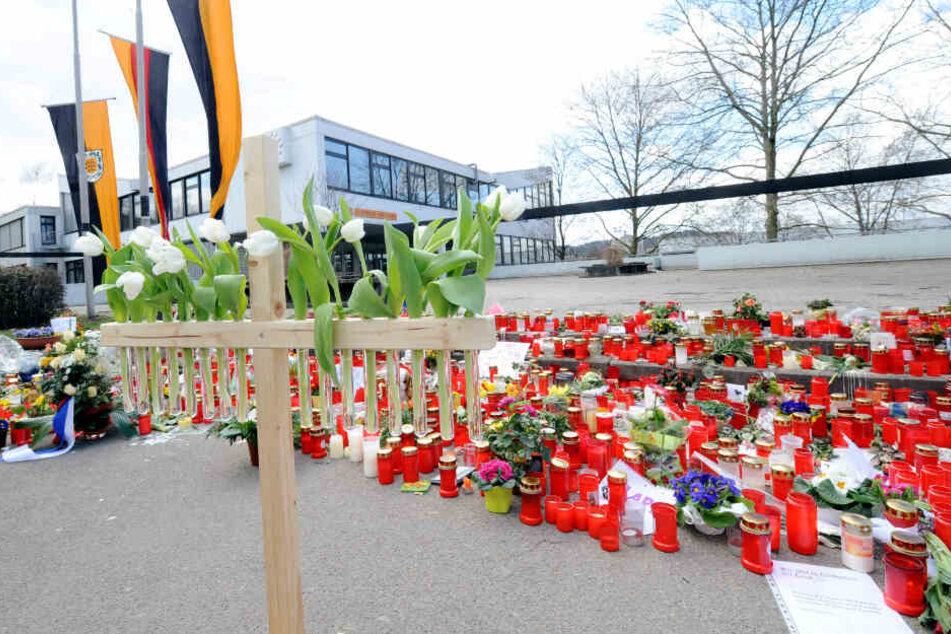 Ein Holzkreuz mit 16 weißen Tulpen steht am 20.03.2009 vor der Albertville-Realschule in Winnenden.