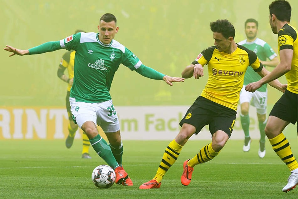 Bremens Maximilian Eggestein (l.) duelliert sich im dichten Nebel mit Dortmunds Thomas Delaney (M.).