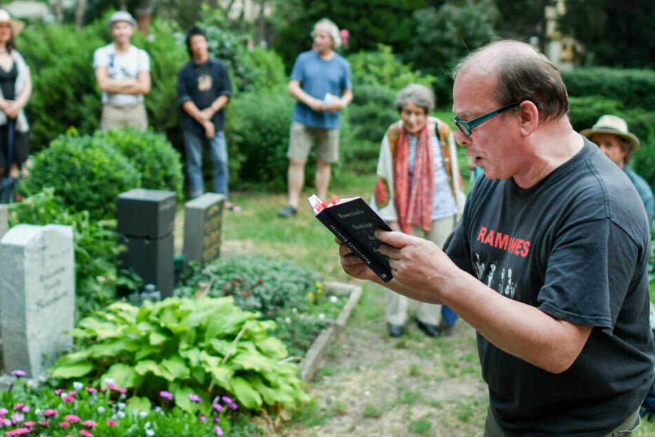 Der Schriftsteller Peter Wawerzinek liest beim Sommerfest im Brecht-Weigel-Haus zur Veranstaltung "Geisterstunde" am späten Abend auf dem Dorotheenstädtischen Friedhof am Grab des Autors Wolfgang Herrndorf.