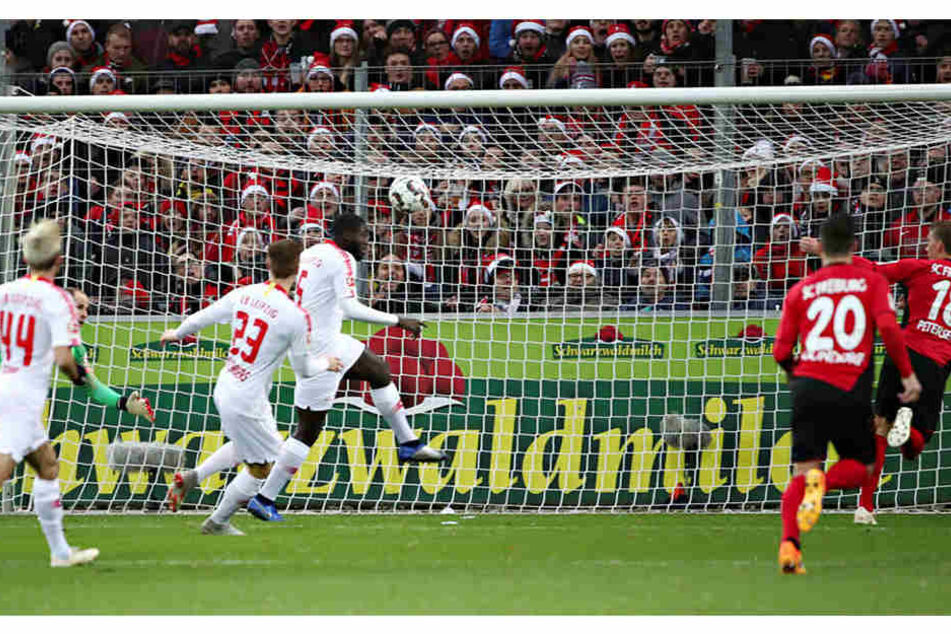 Das 1:0: Nach einem Abpraller von Péter Gulácsi (l., grünes Trikot) stochert Freiburgs Nils Petersen (r.) den Ball aufs Tor. Sowohl der Keeper als auch Ibrahima Konaté (3.v.r.) springen darunter durch.
