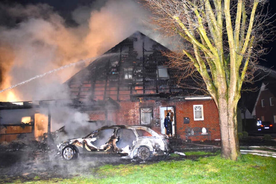 Die völlig bereits ausgebrannten Fahrzeuge und das zerstörte Wohnhaus im Ortskern von Schwanewede sind bei den Löscharbeiten zu sehen.