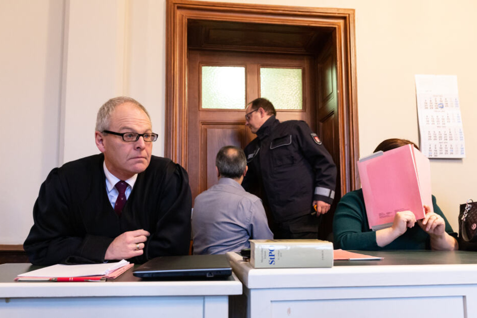 Die 48-jährige Angeklagte verdeckt im Amtsgericht neben Anwalt Uwe Bartscher ihr Gesicht.
