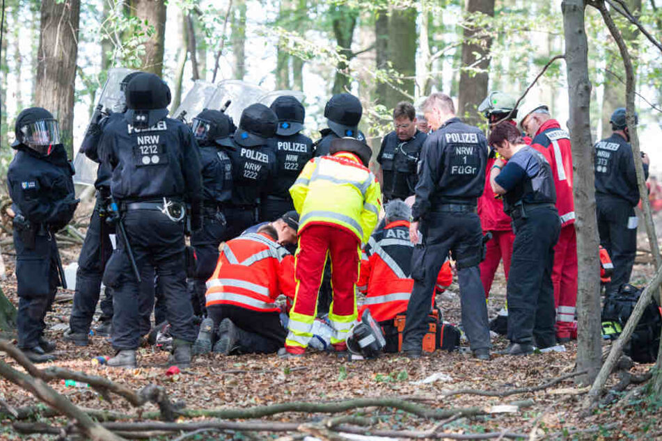 Notärzte versorgen einen Mann, der von einem Baumhaus im Hambacher Forst gefallen ist.