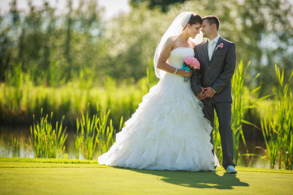 Ein Hochzeitspaar steht auf einer Wiese. (Symbolbild)
