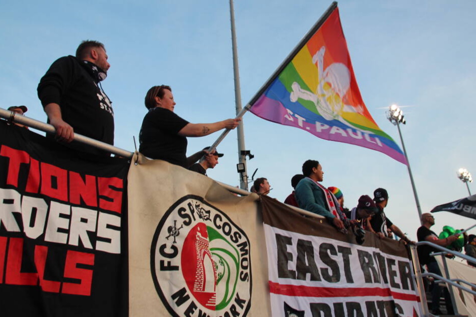 Fans vom FC St. Pauli schwenken beim Freundschaftsspiel der Kiezkicker gegen "New York Cosmos" eine Fahne.