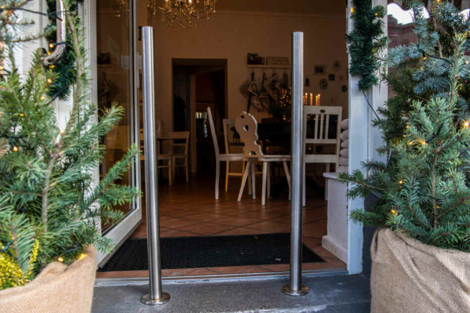 Zwei Poller stehen vor der Eingangstüre eines Cafés in Moabit.