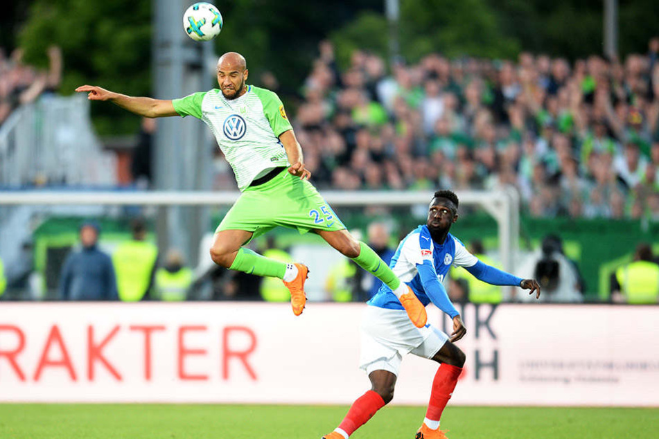 Wolfsburg obenauf: VfL-Verteidiger John Anthony Brooks steht in der Luft, während Kiels Kingsley Schindler staunend zuguckt.