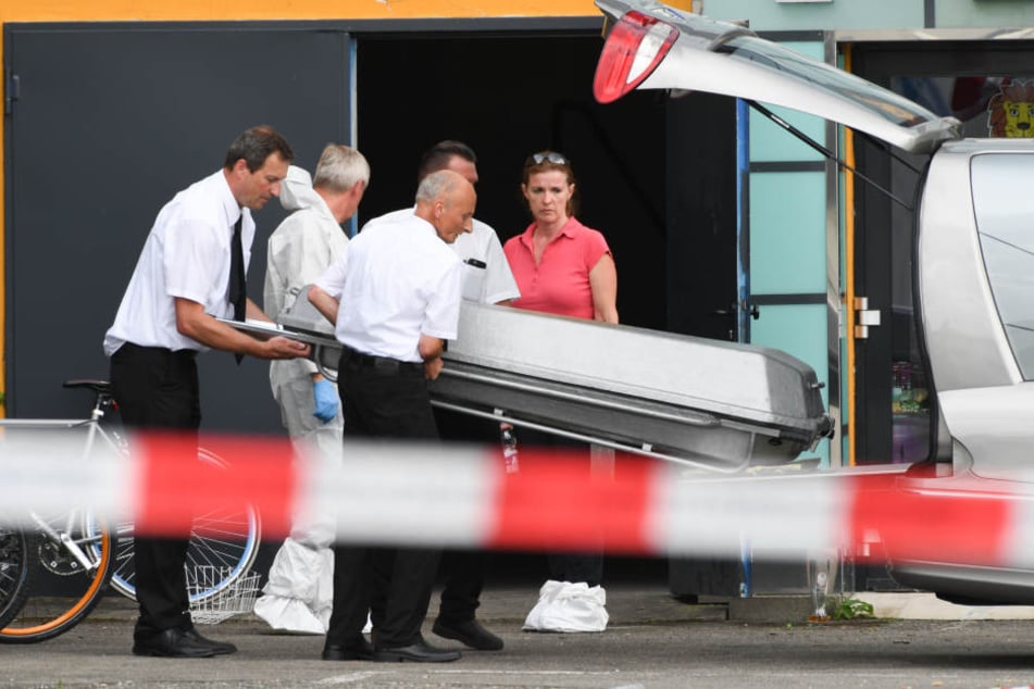 Bestatter tragen den Sarg aus dem Seitenausgang des Club Grey.