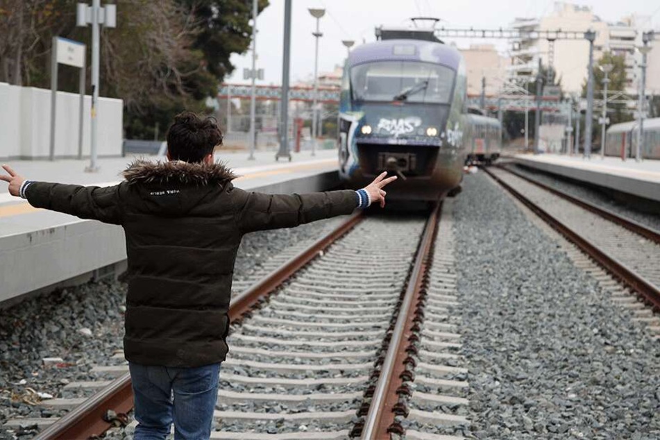 Ein Mann stellt sich auf die Gleise am Bahnhof Athen-Larisa, der von Migranten blockiert wurde, vor einen herannahenden Zug.
