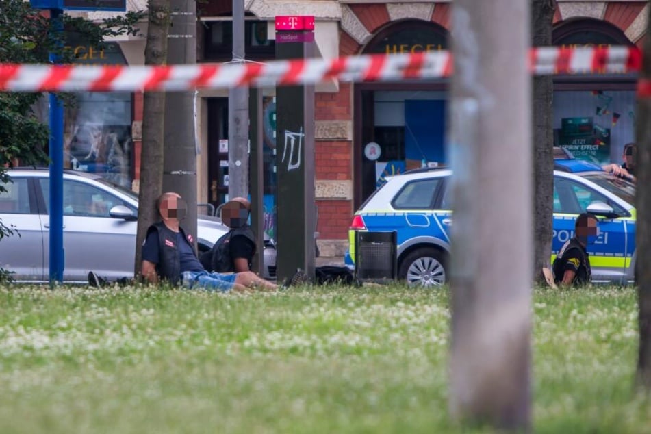 Nach der Schießerei auf der Eisenbahnstraße sitzen festgenommene Hells Angels mit gefesselten Händen in einer Parkanlage. Vier wurden bereits wegen gemeinschaftlichen Mordes zu lebenslanger Haft verurteilt.