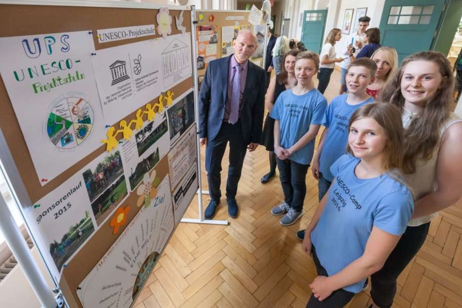 Schuldirektor Ralf Ballmann (55) und Schüler der Klasse 8a vor einer Ausstellungstafel zu den Projekten der Schule.