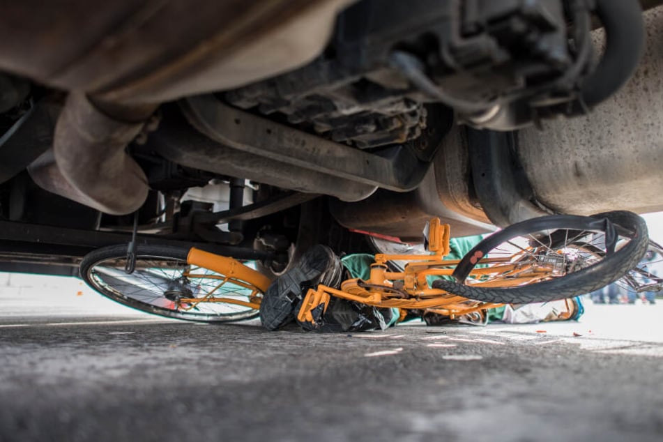 Ein Fahrrad liegt nach einem Unfall völlig zerstört unter einem Lastwagen. (Symbolbild)