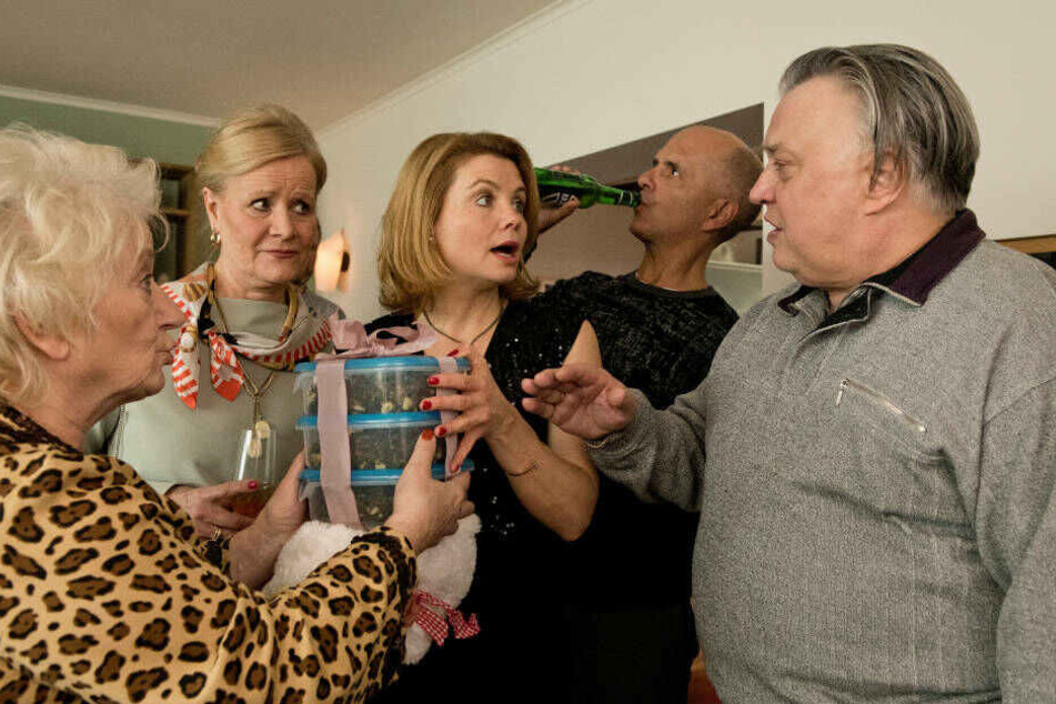 Renate (Carmen-Maja Antoni, l.) und Günter (Bernd Stegemann, r.) überreichen Schiegertochter Anne (Annette Frier, M.) ihr ganz persönliches Geburtstagsgeschenk.